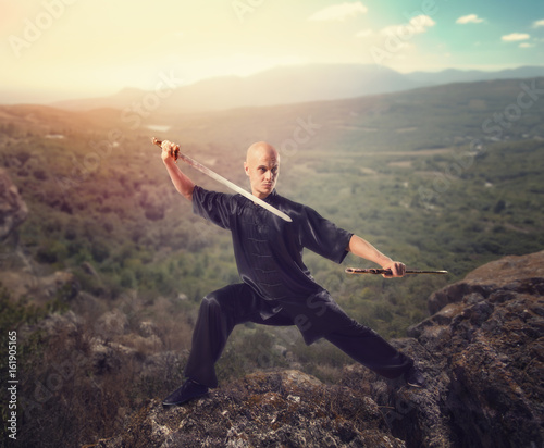Fototapety Kung fu  mistrz-wushu-z-mieczem-medytacja-na-gorze