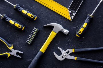 Tools for repairing on black stone table background top view