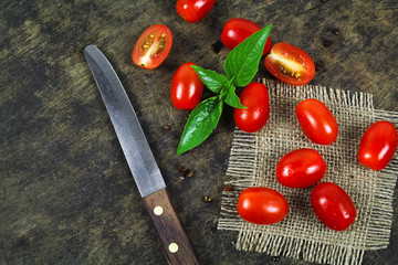 Wall Mural - Cherry tomatoes with basil leaf on a white background