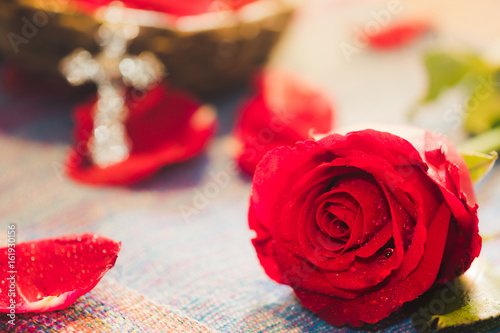 фотография Bright Red Rose with blur metal cross god background