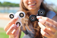 Smiling Women  Hold A White And Black Spinner