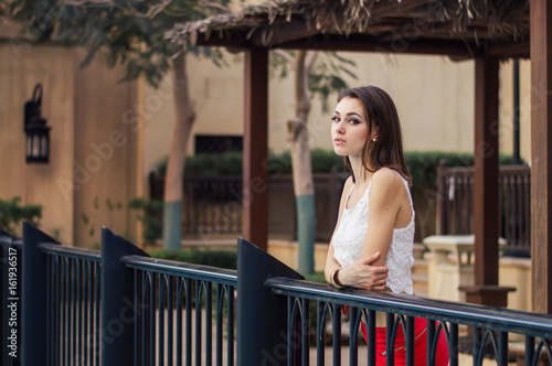 Young European Female In White Crop Top And Red Skirt Standing