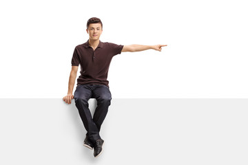 Poster - Teenage boy sitting on a panel and pointing right