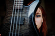 © AS Photo Family - Red haired punk girl wear on black with bass guitar at abadoned place. Portrait of gothic woman musician. Close up face of blackness person with guitar riff.