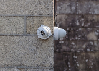 white CCTV camera on a stone wall