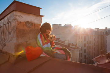 Young beautiful woman on the roof with an umbrella. Romantic walk model girls on the sky background