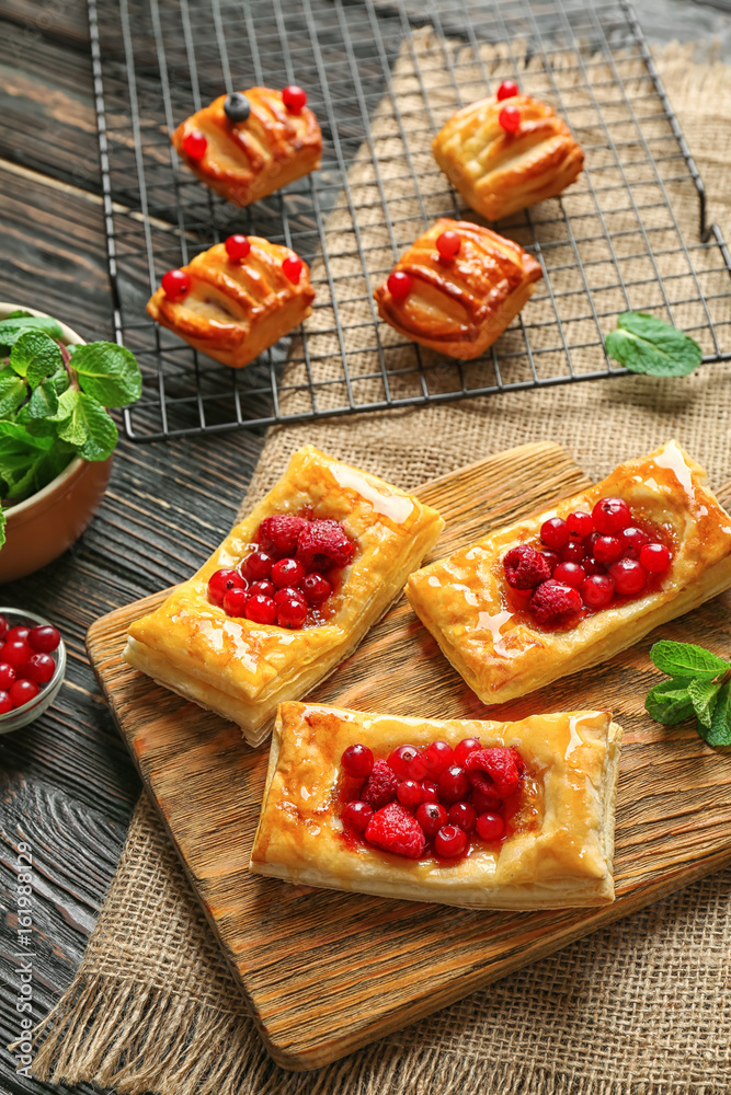 Cutting board and baking rack with pastries on wooden table