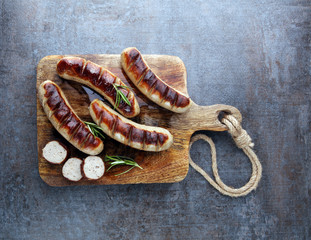 Wall Mural - Grilled sausages with sauce ketchup on a wooden table - Home-made Pork Sausages