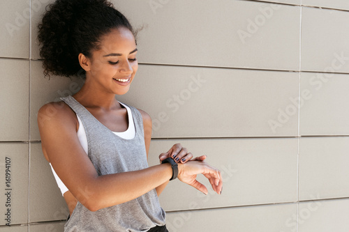 Fotografía Fitness woman taking a break, checking activity tracker