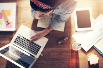 thoughtful young businesswoman browsing laptop at workplace