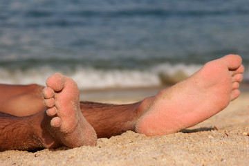 a pair of sandy feet on a sandy beach