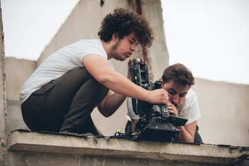 Behind the scene. Cameraman and assistant shooting film with camera