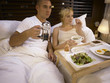 © eskay lim - Couple having breakfast on bed