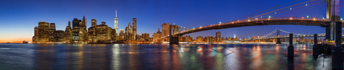 Wall Mural - Panoramic view of Lower Manhattan Financial District skyscrapers at twilight with the Brooklyn Bridge and the East River. New York City