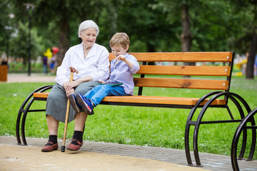 Wall Mural - Young boy and his great grandmother using tablet in park