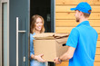 © lenets_tan - Smiling delivery man in blue uniform delivering parcel box to recipient - courier service concept