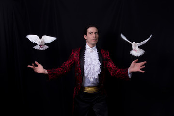 The magician with a two flying white Doves