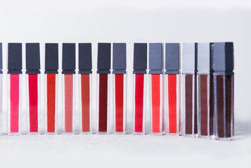 a lot of bright lipsticks are in a row on white background