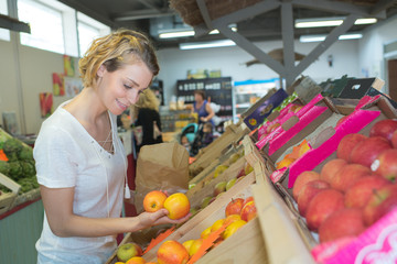 Wall Mural - girl buying fruits at the local market