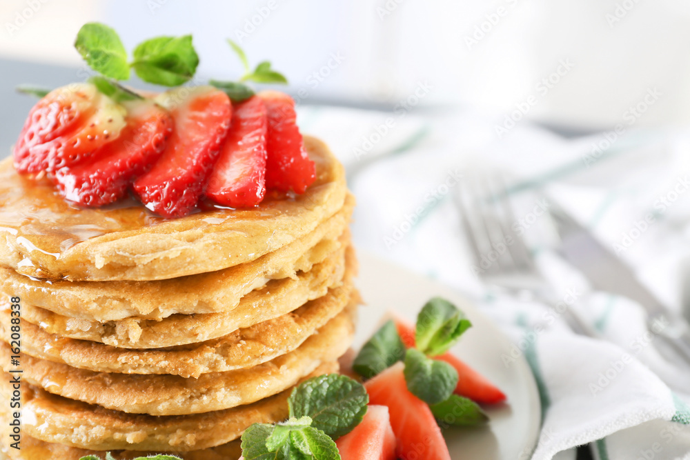 Delicious coconut pancakes with sliced strawberry and mint, close up