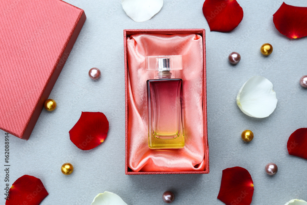Perfume in present box on gray background