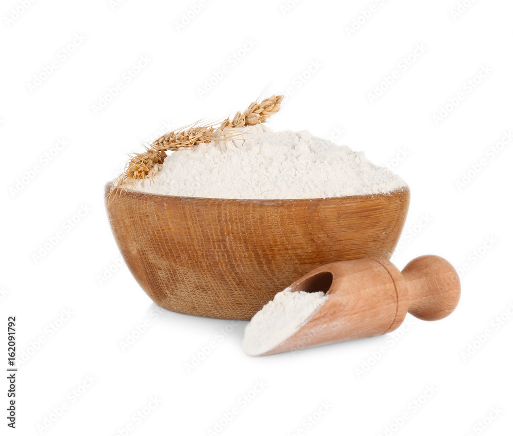 Wooden bowl and scoop with flour on white background