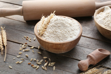 Composition with flour and kitchen utensils on wooden background