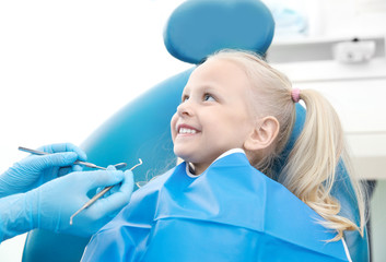 Wall Mural - Dentist examining little girl's teeth in clinic