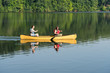 © steheap - Couple paddling in yellow canoe on tree lined lake