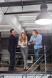 © mast3r - Businesspeople Team Sharing Ideas Stand On Staircase Modern Creative Office Interior Brainstorming Concept, Business Men And Woman Meeting Discussing New Startup Project