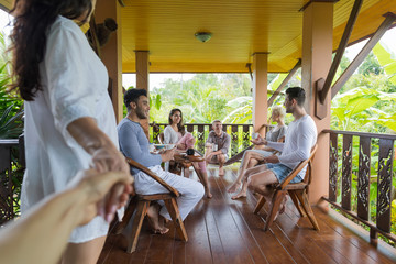 Wall Mural - Woman Hold Man Hand Enter Summer Terrace With People Group Talking, Friends Outdoors Happy Smiling Communication