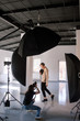 © Photodrive - Photographer and model during studio session. Unrecognizable woman taking shot of male model in studio. Photo school, lookbook, fashion backstage concept