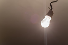 Burning Light Bulb Hangs From Ceiling