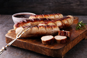 Wall Mural - Grilled sausages with sauce ketchup on a wooden table - Home-made Pork Sausages