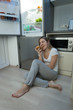 © Kyrylo Ryzhov - Young sleepless woman sitting on kitchen floor and eating pizza