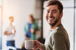 © Yakobchuk Olena - Cheerful male freelancer drinking hot beverage