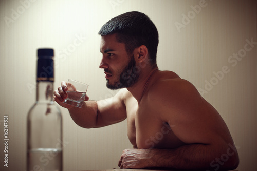 Fotografia, Obraz Young caucasian man drinking alcohol at home