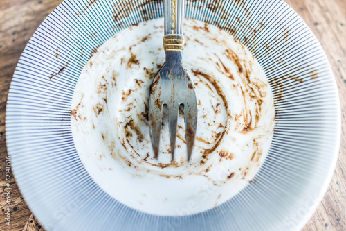 Fotografie, Obraz Dirty dessert plate with fork after a meal of chocolate cake with crumbs