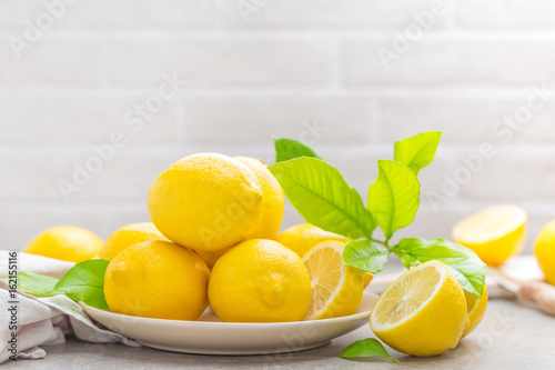swieze-cytryny-na-bialym-okraglym-talerzu-w-kuchnii