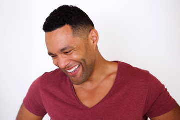 happy african american man looking down and smiling against white background
