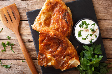 Canvas Print - Balkan food: burek with spinach and cheese close-up on the table. Horizontal top view