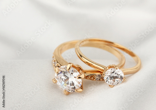 Plakat pierścienie biżuterii z diamentem na białym obrusem, nieostrość