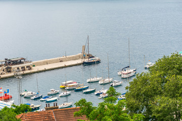 Wall Mural - MONTENEGRO, HERCEG NOVI - MAY 27/2017: travelers park their ships on a pre-island near the city coast.