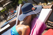 Young woman sunbathing by the pool. Tanning on the beach. Summer and vacation concept.