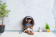 © Inna Vlasova - cute African girl at home, listening to music in big white headphones