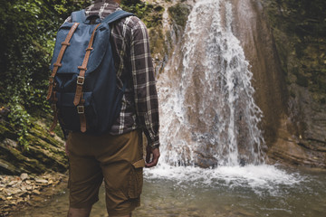 Wall Mural - Unrecognizable Young Man Has Reached Destination And Enjoying View Of Waterfall. Journey Hiking Adventure Concept