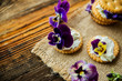 Sandwich with herb and edible flowers butter on wooden background, healthy food.