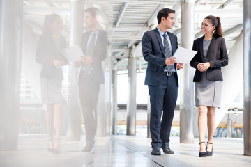 Wall Mural - Businessman and businesswoman discussing work while walking