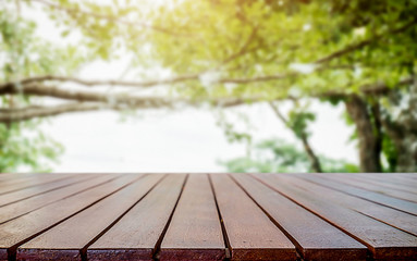 Empty wooden table space platform and blurred flower garden background for product display montage.