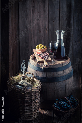 czerwone-wino-w-karafce-i-przekaski-w-drewnianej-piwnicy